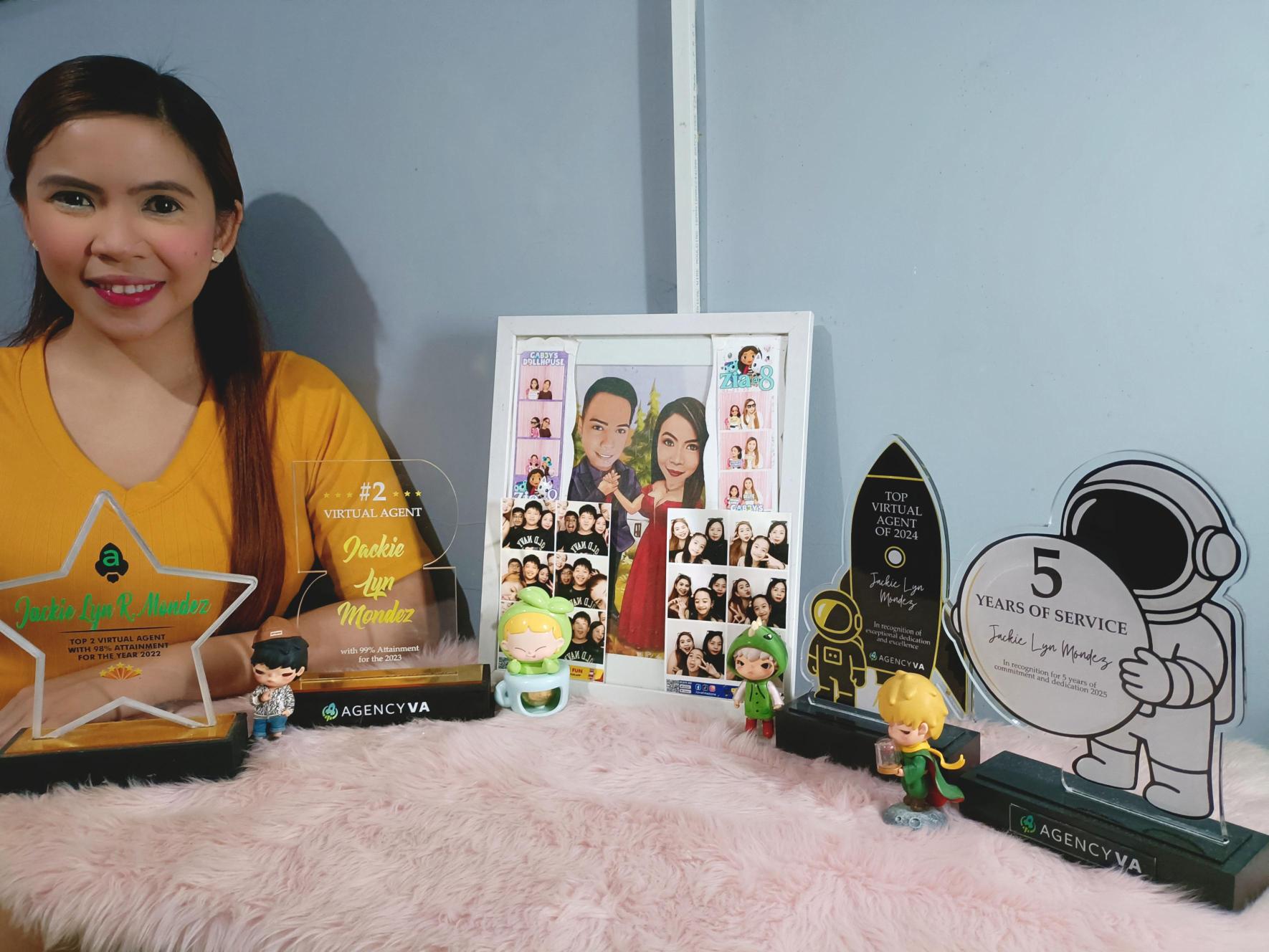 Jackie, a top-performing Virtual Assistant at Agency VA, proudly displaying her consistent "Top Performer" awards and plaques at her home office.